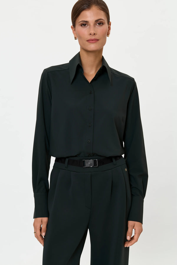 Women's ORLOV forest green shirt styled with SICANI stretch pants, showcasing a tailored silhouette, pointed collar, and modern monochromatic outfit.