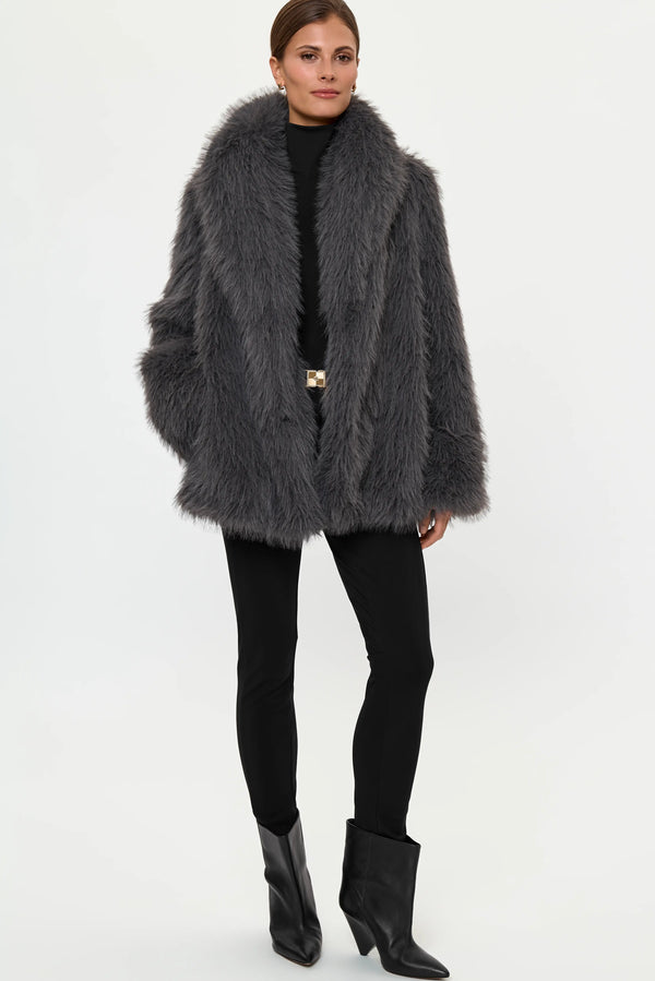 Woman wearing a crystal grey faux fur coat with black leggings and black ankle boots